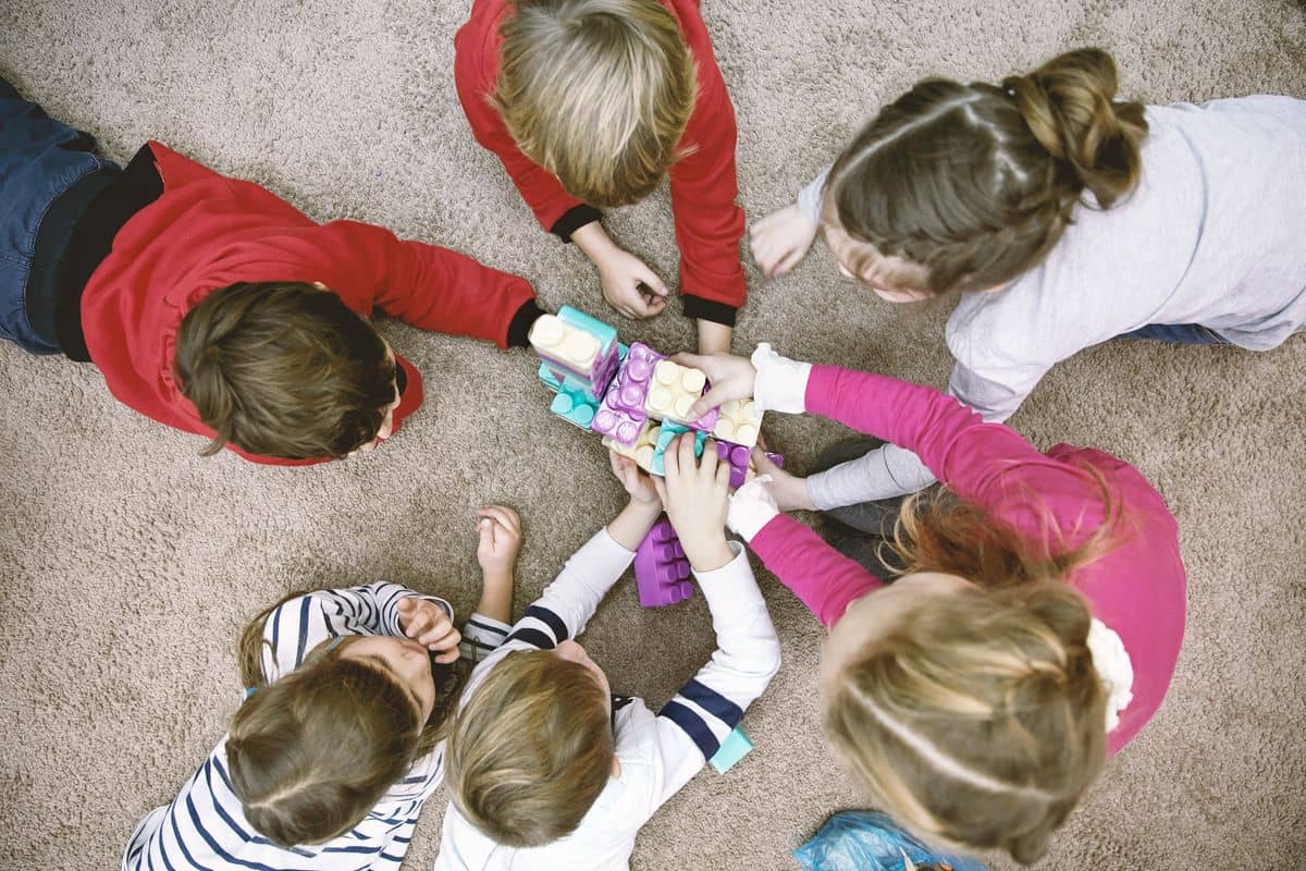 Kinder sitzen im Kreis und spielen