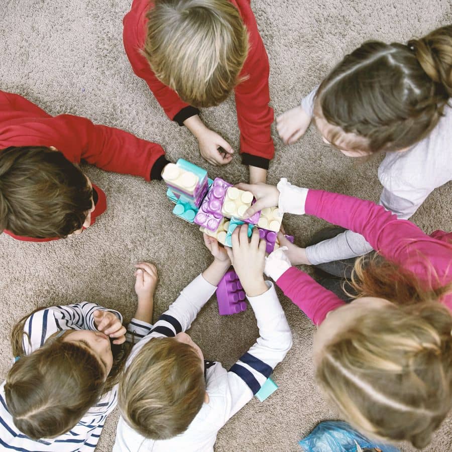 Kinder sitzen im Kreis und spielen