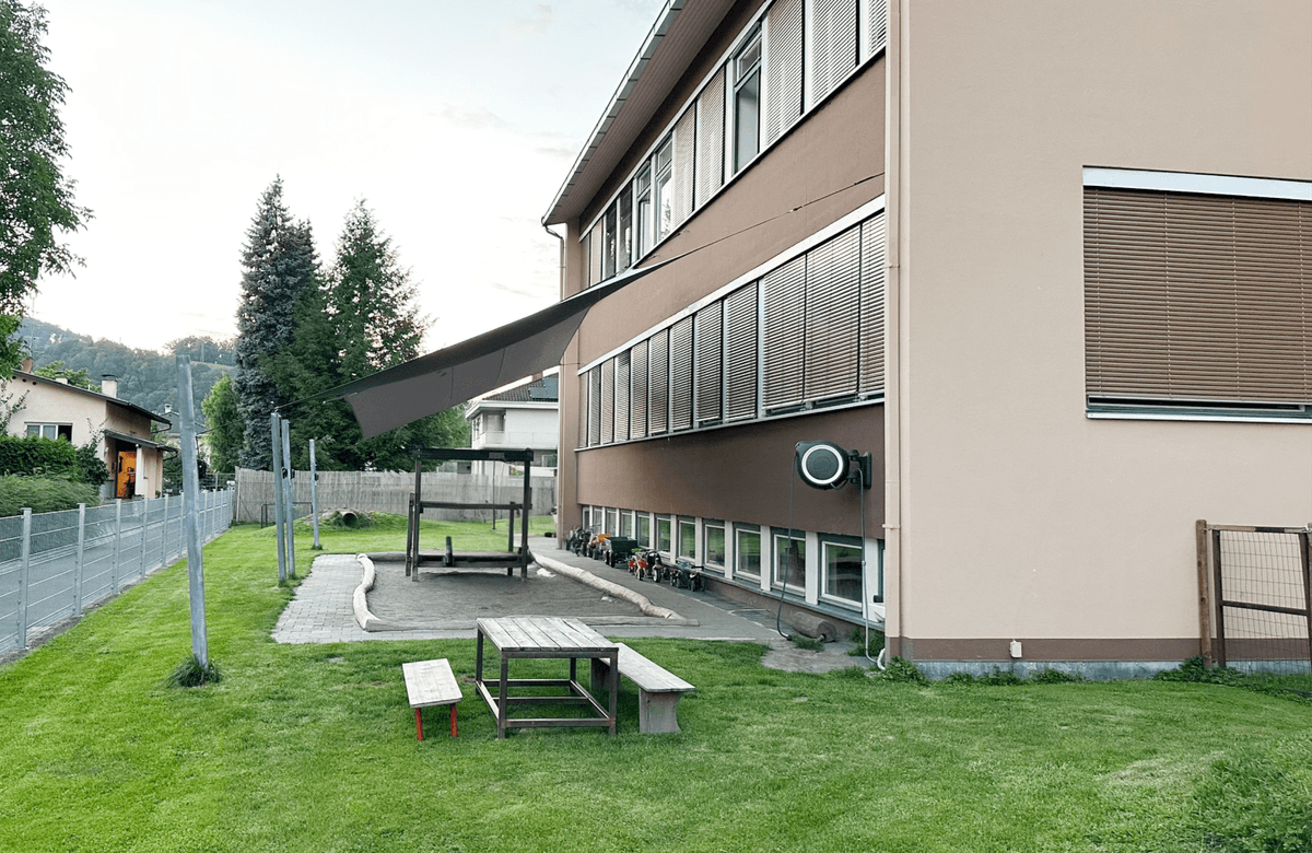 Garten der Kinderkrippe mit Sandkasten und Sitzbereich